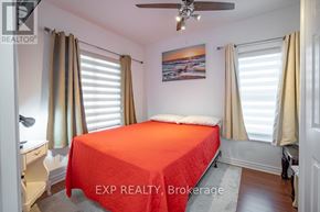Niagara Falls (Arad/Fallsview) apartment for rent - A bedroom with a red bedspread and a ceiling fan.