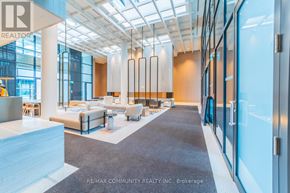 Vaughan (Vaughan Corporate Centre) condo for rent - A spacious office lobby with a seating area and a glass wall.