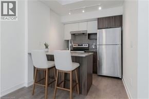Burlington townhouse for rent - A modern kitchen with white chairs and a stainless steel refrigerator.