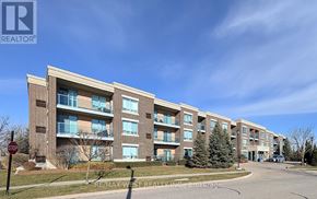 Brampton (Sandringham-Wellington) condo for rent - A multi-story apartment building with a stop sign in front.