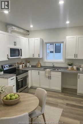 Windsor apartment for rent - A kitchen with white cabinets and a wooden table with a bowl of fruit on it.