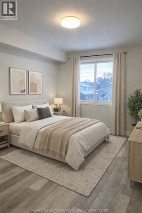 Windsor apartment for rent - A well-lit bedroom with a large bed and a view of the outside through the window.