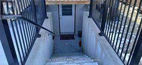 Clarington (Bowmanville) apartment for rent - A stairway with a black railing and a white door.