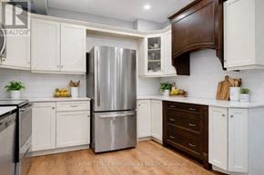 Casselman apartment for rent - A kitchen with white cabinets and a stainless steel refrigerator.