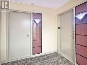 Toronto (Woburn) condo for rent - A hallway with a door on the left and a glass door on the right.