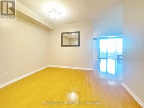 Toronto (Woburn) condo for rent - A room with a wooden floor and a mirror on the wall.