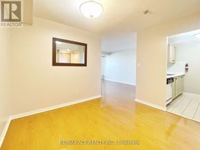 Toronto (Woburn) condo for rent - A room with a wooden floor and a mirror on the wall.