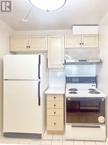 Toronto (Woburn) condo for rent - A white refrigerator and oven in a kitchen.