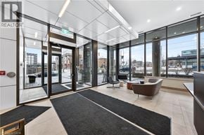 Kitchener condo for rent - A modern office lobby with a black and white carpet, a brown leather chair, and a glass wall overlooking the city.