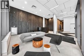 Kitchener condo for rent - A modern living room with a grey sofa, a wooden coffee table, and a black rug.