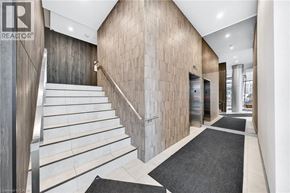 Kitchener condo for rent - A staircase with a wooden handrail and white steps leads up to a door.