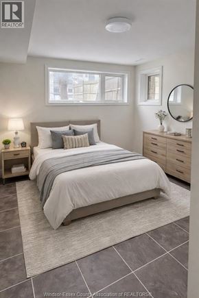 Windsor apartment for rent - A bedroom with a bed, nightstand, and a mirror.