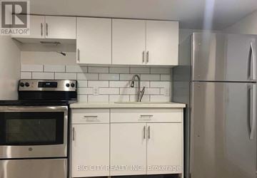 Toronto (Rockcliffe-Smythe) apartment for rent - A kitchen with white cabinets and stainless steel appliances.