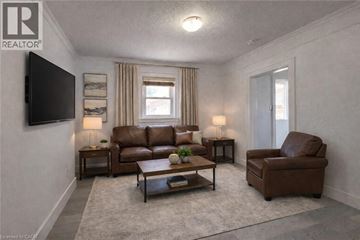 Kitchener apartment for rent - A living room with a brown leather couch and a grey rug.