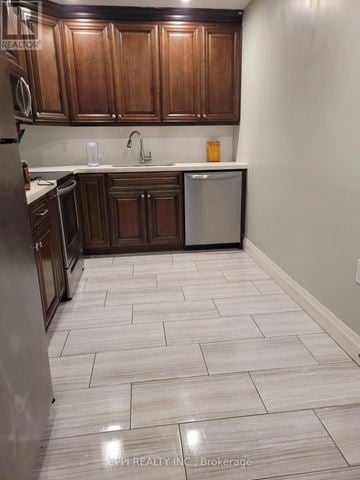 Port Colborne (Main Street) multi-family for rent - A kitchen with wooden cabinets and a tiled floor.