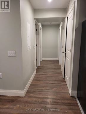 Port Colborne (Main Street) multi-family for rent - A long hallway with white walls and wood floors.