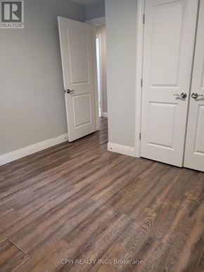Port Colborne (Main Street) multi-family for rent - A room with wood flooring and two white doors.