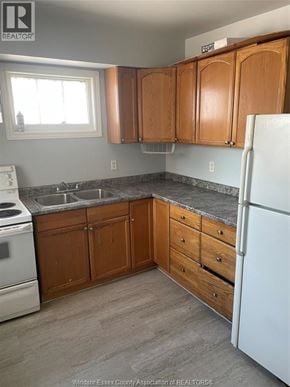 Windsor apartment for rent - A kitchen with wooden cabinets and a white fridge.