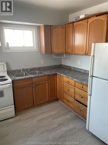 Windsor apartment for rent - A kitchen with wooden cabinets and a white fridge.