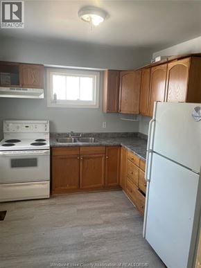 Windsor apartment for rent - A kitchen with a white fridge, stove and oven.