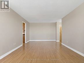 Ajax (Central West) condo for rent - A spacious room with wooden flooring and white walls.