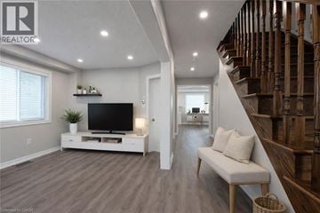 Brantford apartment for rent - A living room with a television and a staircase.