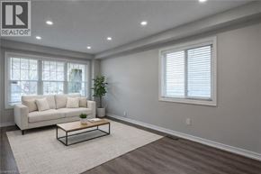 Brantford apartment for rent - A living room with a white couch, a coffee table, and a plant.