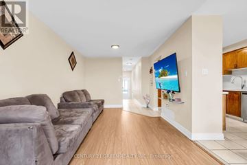 Mississauga (Churchill Meadows) townhouse for rent - A living room with a grey couch and a flat screen TV mounted on the wall.