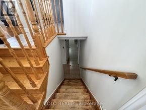 Hamilton (Jerome) apartment for rent - A wooden staircase with a white wall and a glass door in the background.