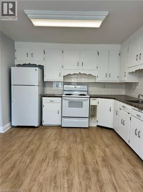 Kitchener apartment for rent - A kitchen with white appliances and cabinets.