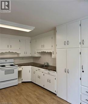 Kitchener apartment for rent - A kitchen with white cabinets and a stove top oven.