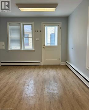 Kitchener apartment for rent - A room with a door, window, and wooden floor.