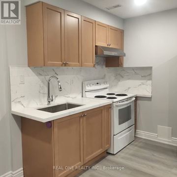 Toronto (Willowdale East) apartment for rent - A kitchen with brown cabinets and a white stove top oven.