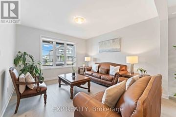 Ottawa apartment for rent - A living room with a brown leather couch and a wooden chair.