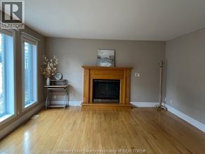 Windsor apartment for rent - A living room with a fireplace and a vase of flowers on the side table.