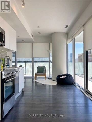 Toronto (Church-Yonge Corridor) condo for rent - A modern kitchen with a stove top oven and a chair.
