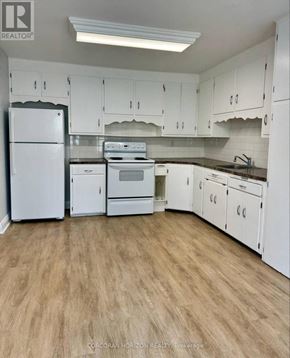 Kitchener apartment for rent - A kitchen with white appliances and cabinets.