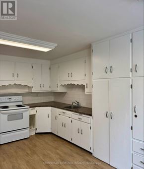 Kitchener apartment for rent - A kitchen with white cabinets and a stove top oven.