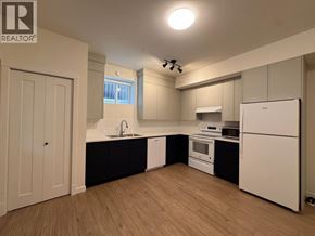 Maple Ridge apartment for rent - A kitchen with white appliances and wooden floors.