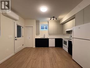 Maple Ridge apartment for rent - A kitchen with white appliances and wooden floors.