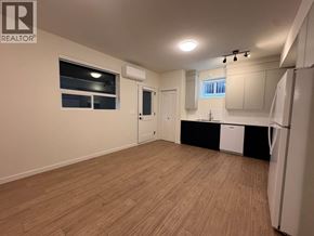 Maple Ridge apartment for rent - A well-lit, empty room with wooden flooring and white walls.