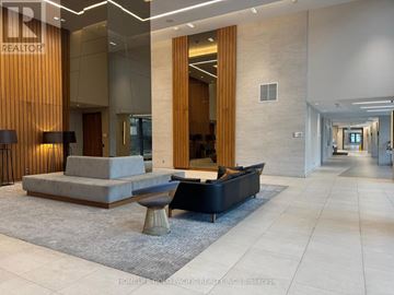Toronto (Flemingdon Park) condo for rent - A modern living room with a grey sofa and a round table.
