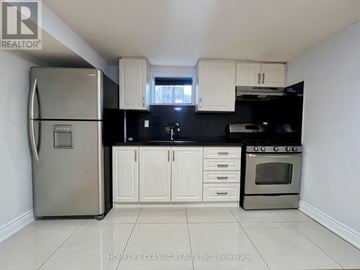 Toronto (Willowdale East) apartment for rent - A kitchen with white cabinets and a stainless steel refrigerator.