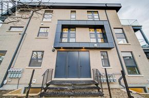 Toronto (Little Portugal) multi-family for rent - A modern two-story building with a black front door and windows.