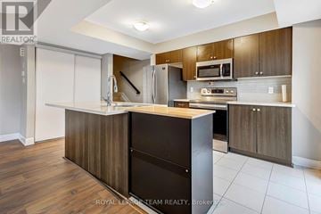 Ottawa townhouse for rent - A modern kitchen with wooden cabinets and a central island.