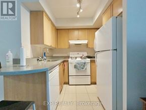 Toronto (Bayview Village) condo for rent - A kitchen with wooden cabinets and a white refrigerator.