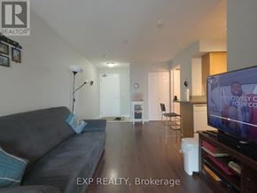 Toronto (Bayview Village) condo for rent - A living room with a grey couch and a television on.
