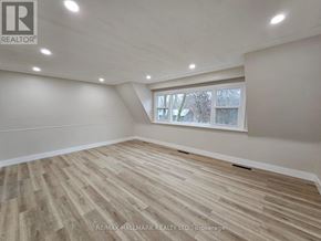 Richmond Hill (Mill Pond) apartment for rent - A room with wooden flooring and a window showing a tree outside.
