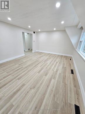 Richmond Hill (Mill Pond) apartment for rent - A spacious room with wooden flooring and a doorway leading to another room.