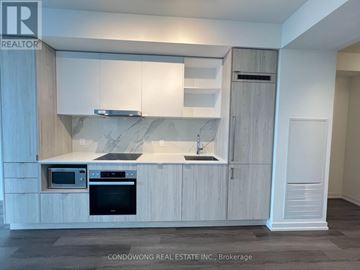 Toronto (Waterfront Communities) condo for rent - A modern kitchen with white cabinets and a marble backsplash.